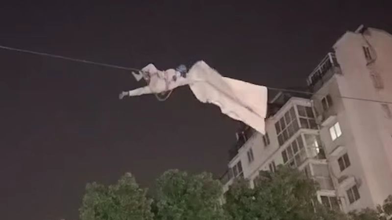 居民晒的被子掉落在高压线上 电力工人深夜徒手攀爬取下